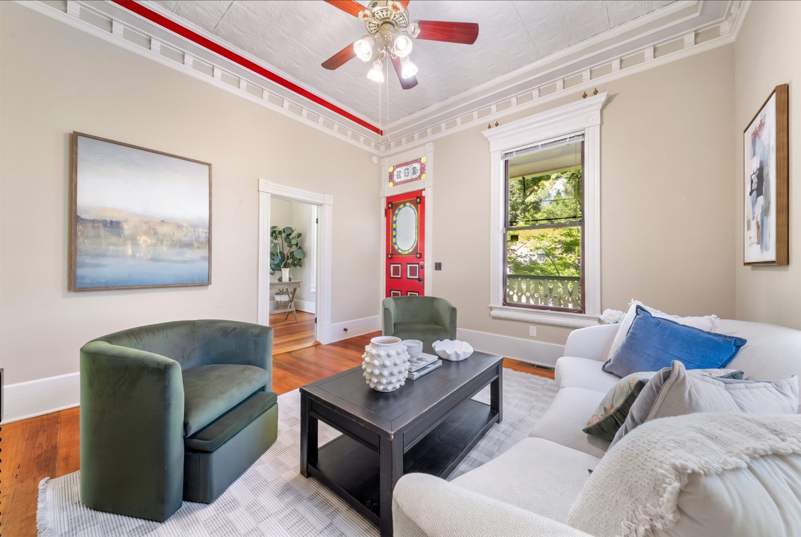 Living room with pressed tin ceiling and original red entry door